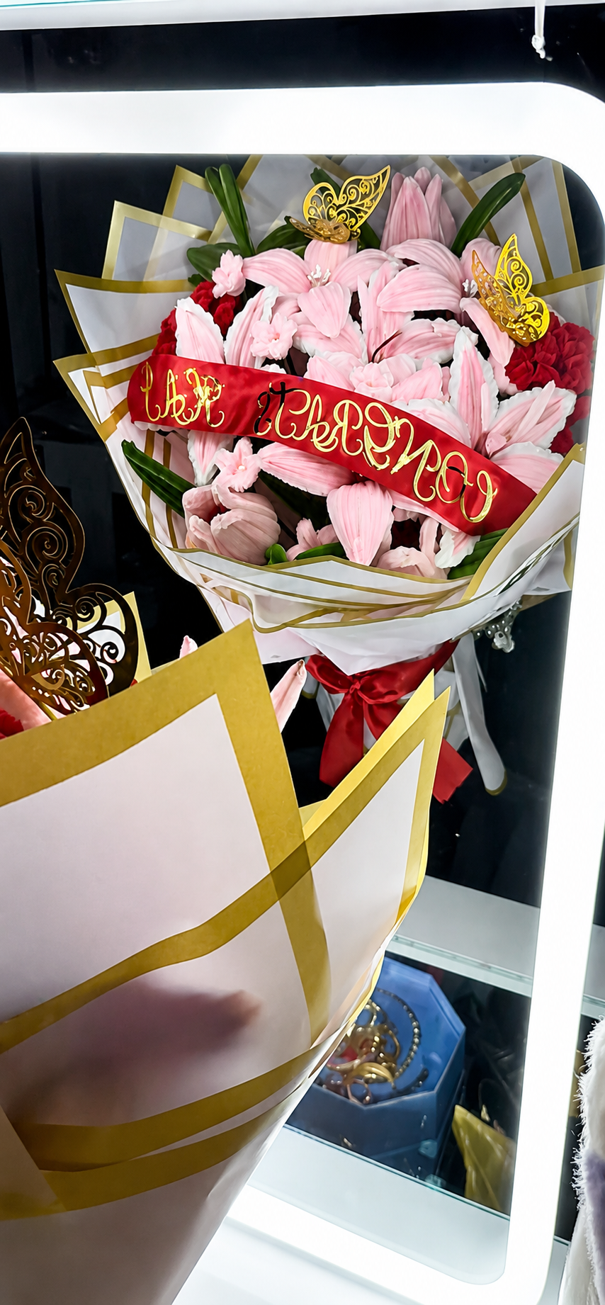 Pink lily graduation bouquet with red ribbon and gold butterflies