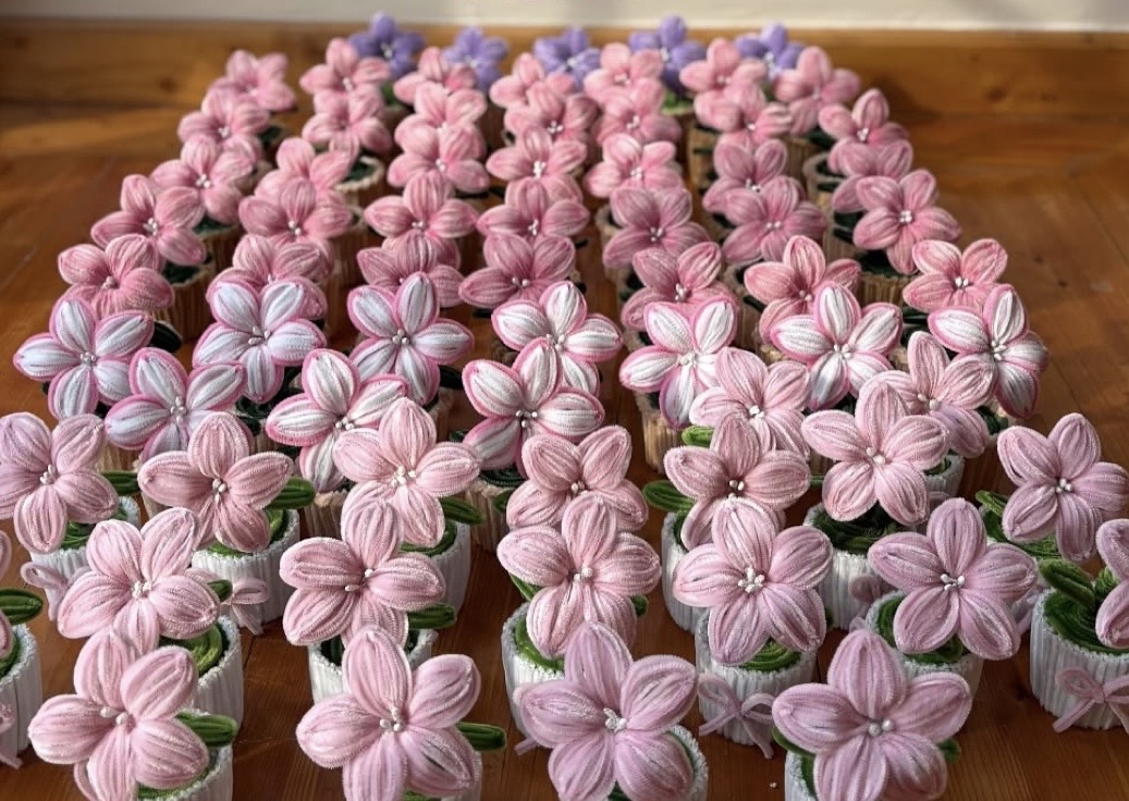 Dozens of mini pipe cleaner flower pots in pink and lavender — party favors